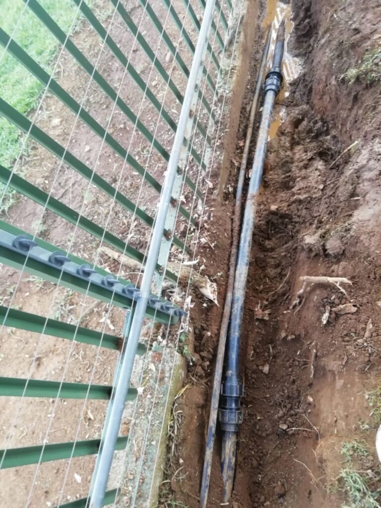 Exposed water pipe along a boundary fence