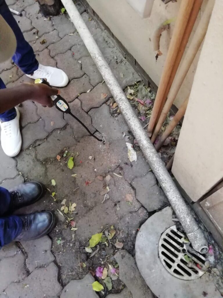 Plumbing work beside paving and a drain